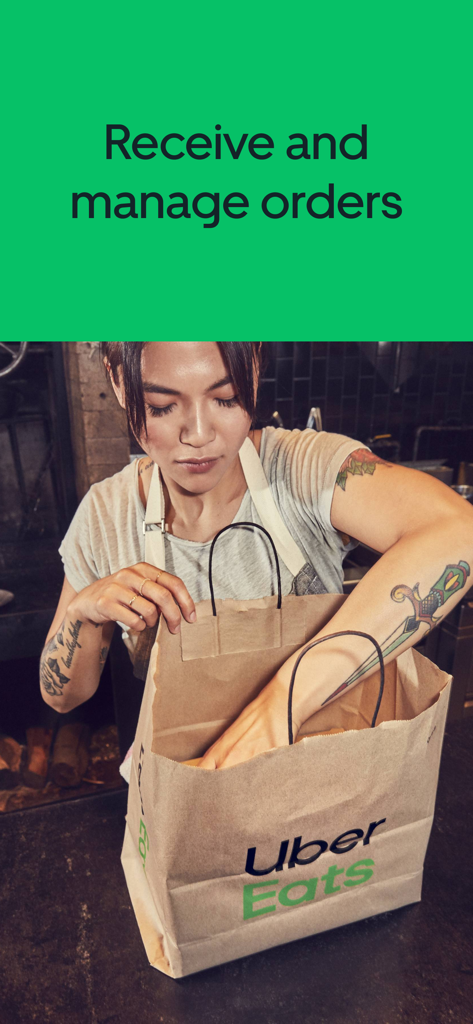 A restaurant worker packing a delivery bag with the Uber Eats logo