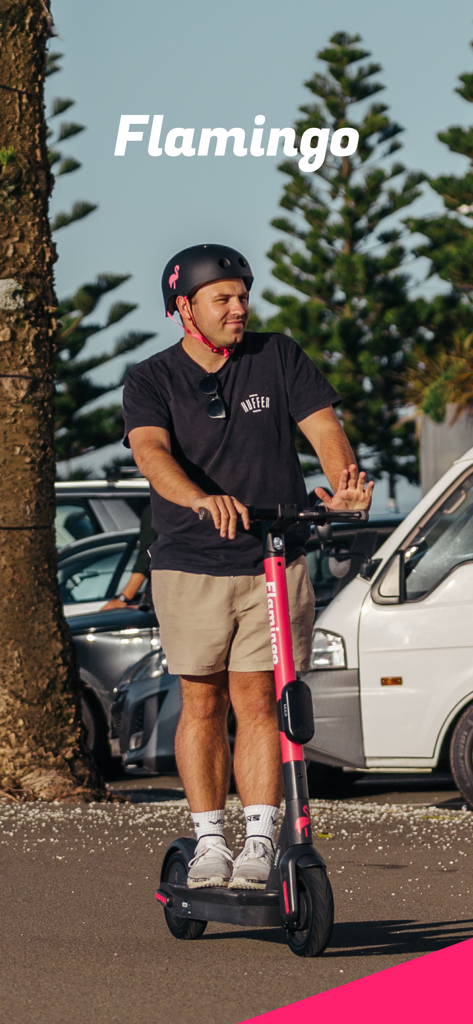 Flamingo Scooters - A man wearing a helmet riding a pink Flamingo electric scooter in a city setting