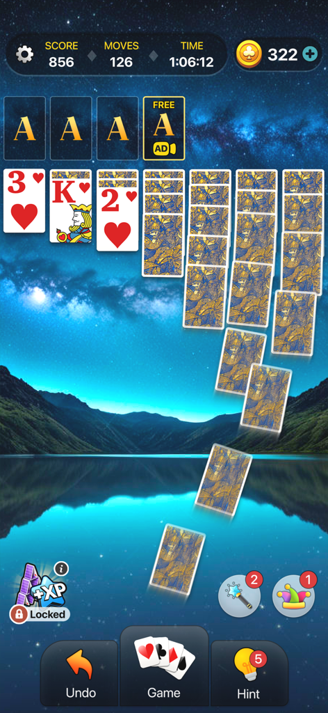 Klondike Solitaire- Card Games - Una pantalla de juego móvil del Solitario Klondike con cartas grandes sobre un pintoresco lago de montaña de fondo por la noche.