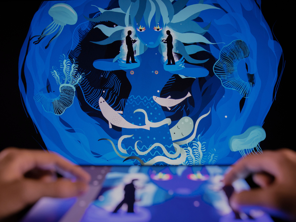 Manos usando Tagtool SE en un iPad para crear una proyección de arte digital submarino en vivo