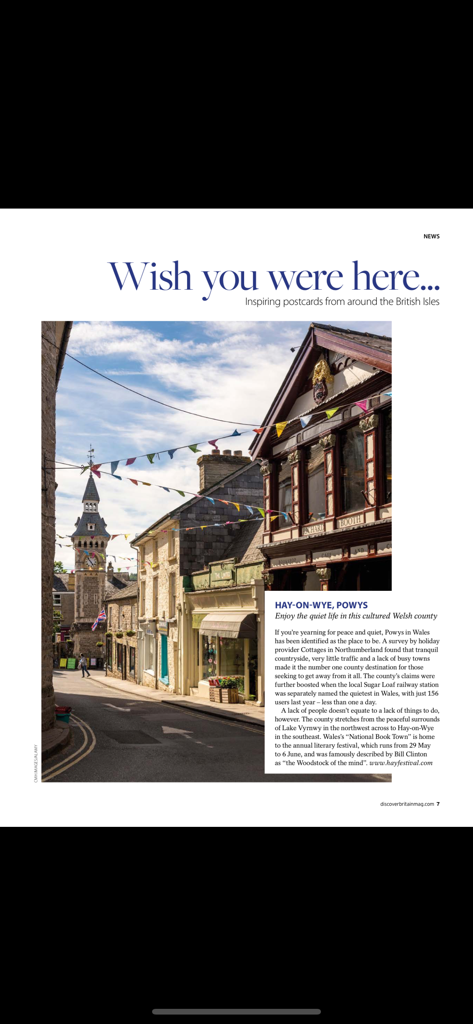 Discover Britain Magazine - A scenic street view of Hay on Wye in Wales featuring traditional architecture and colorful bunting
