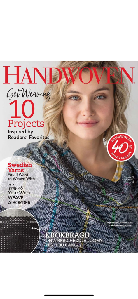 Handwoven - The front cover of Handwoven magazine's 40th anniversary issue featuring a woman wearing a geometric patterned shawl.