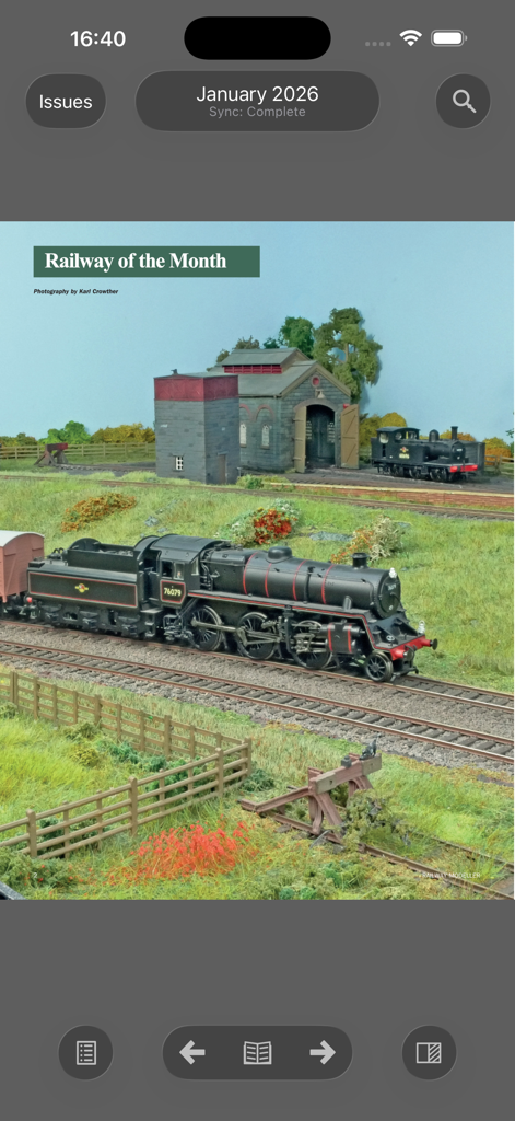 Railway Modeller - Uma página digital da revista Railway Modeller apresentando uma locomotiva a vapor modelo detalhada em um layout de ferrovia em miniatura.