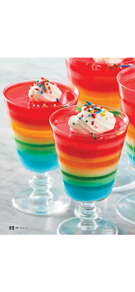 Cocina Fácil - Rainbow layered gelatin dessert topped with whipped cream and colorful sprinkles