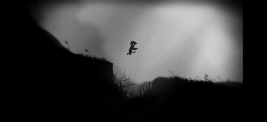 Playdead's LIMBO - Una silueta de un niño saltando sobre un pozo de pinchos en el mundo oscuro y brumoso de LIMBO de Playdead