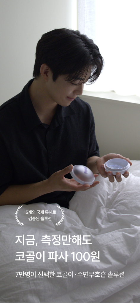 A man sitting on a bed looking at a PASA snore tracker oral appliance container