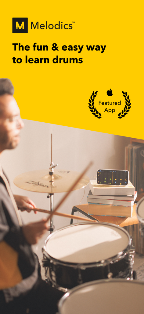 Melodics: Drum Lessons App - Una persona practicando batería en un set acústico mientras usa la aplicación Melodics en un iPhone para obtener retroalimentación en tiempo real.