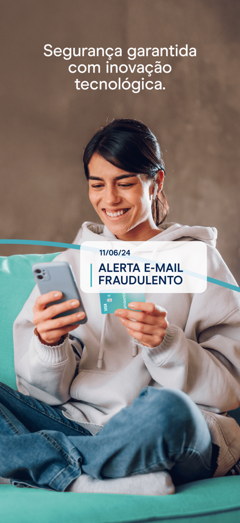 APP UNIBANCO - A woman holding a smartphone and credit card while viewing a security alert notification in the Unibanco app