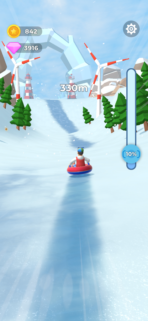 Pantalla de juego de Sled Surfers mostrando un personaje deslizándose por un camino montañoso nevado con turbinas eólicas y árboles