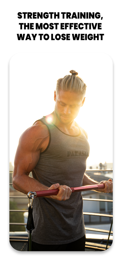 A man performs strength training with resistance bands on a rooftop at sunset