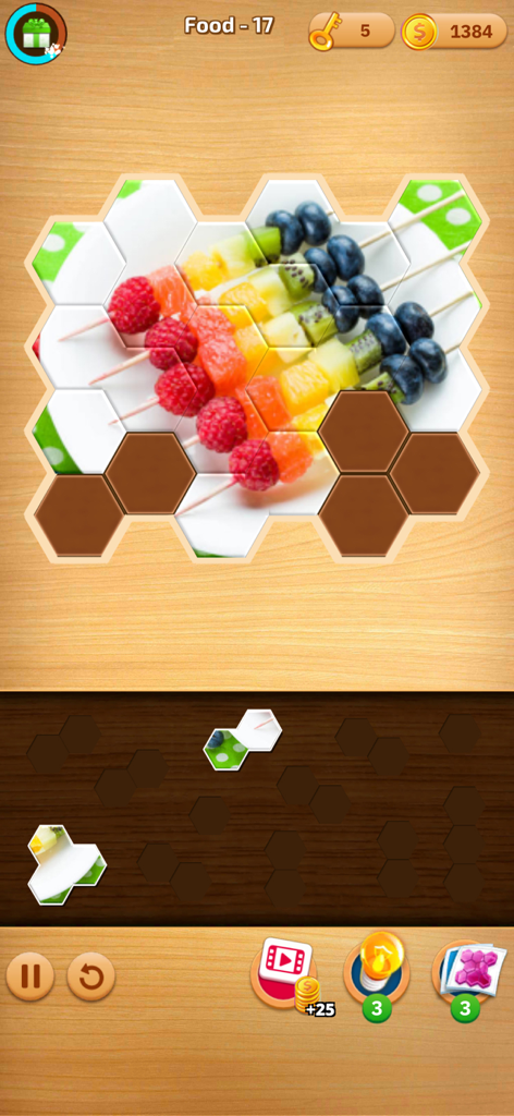Captura de tela da jogabilidade de um quebra-cabeça hexagonal apresentando uma imagem colorida de um espetinho de frutas