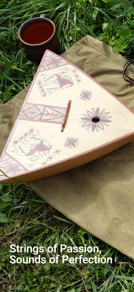 Balalaika - A traditional triangular wooden balalaika with folk art patterns resting on grass next to a ceramic cup.