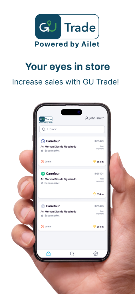 Hand holding a smartphone displaying the GU Trade app interface with a list of store locations for retail execution.