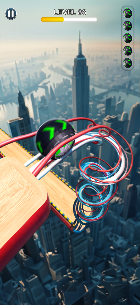 A black rolling ball with green arrows moving along a colorful spiral track high above a city skyline
