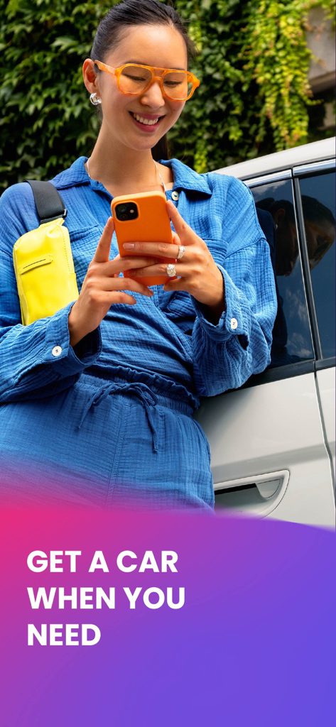 A stylish young professional leaning against a car while using the Free2move app on her smartphone