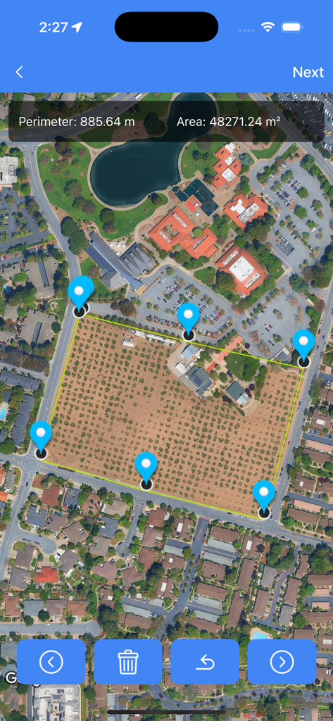 GPS Area Measure - FieldCal - Uma visualização de mapa de satélite mostrando a área do terreno e a medição do perímetro com pinos azuis em um campo