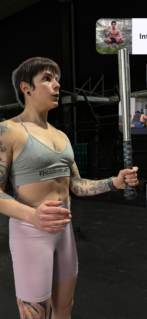 A woman performing a strength training exercise with a steel mace using the Silverback Training app