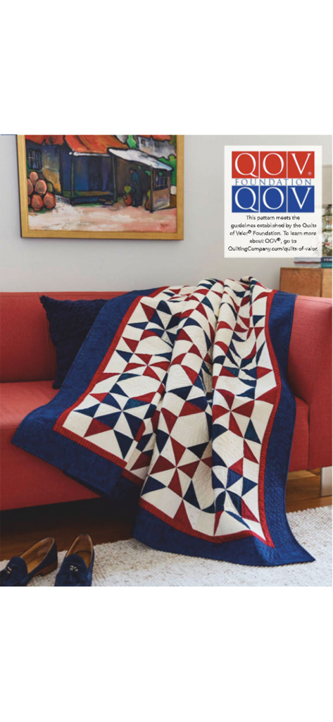 A patriotic red white and blue star patterned quilt draped over a red sofa