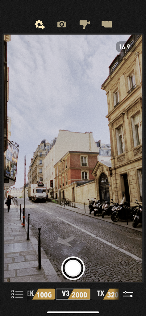 Interfaz de la aplicación Cámara Vintage de 8mm mostrando un efecto de película retro en vivo en una vista de calle europea.
