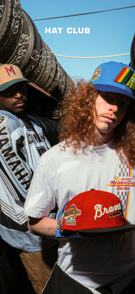 Two men showcasing exclusive Hat Club fitted hats and streetwear in an urban setting
