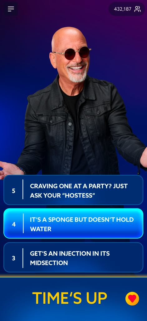 Best Guess Live - Il conduttore Howie Mandel in una sessione dal vivo dell'app di trivia Best Guess Live di Netflix con indizi di enigmi e una notifica di tempo scaduto visualizzati sullo schermo.