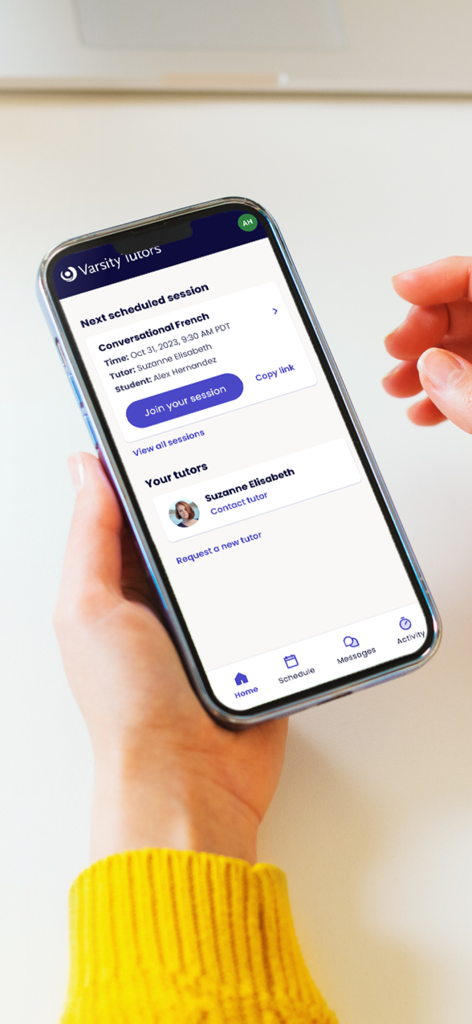 Varsity Tutorsアプリのホーム画面が表示されたiPhoneを手に持ち、予約済みのフランス語個別指導セッションと参加ボタンが表示されています。
