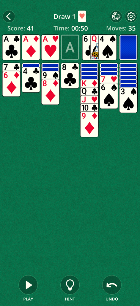 A classic Klondike solitaire game in progress on a green felt background.