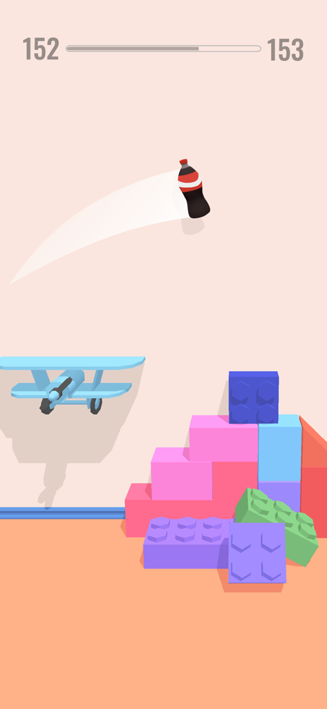 Bottle Jump 3D - Eine Limonadenflasche dreht sich in einer 3D-Umgebung über bunten Bauklötzen und einem blauen Flugzeug.