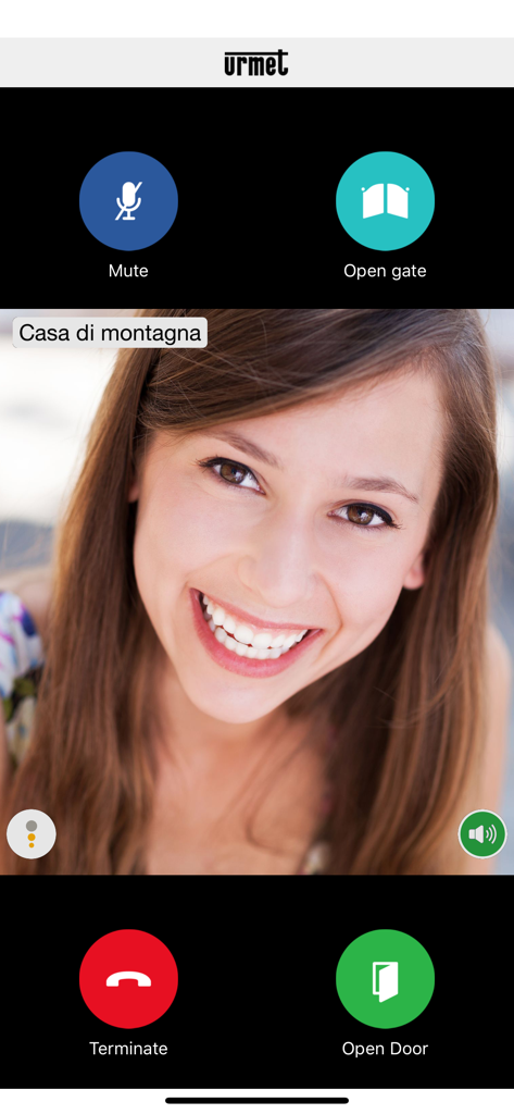 Urmet CallMe - Interfaz de la app Urmet CallMe mostrando una videollamada del interfono con botones de control remoto de puerta y cancela