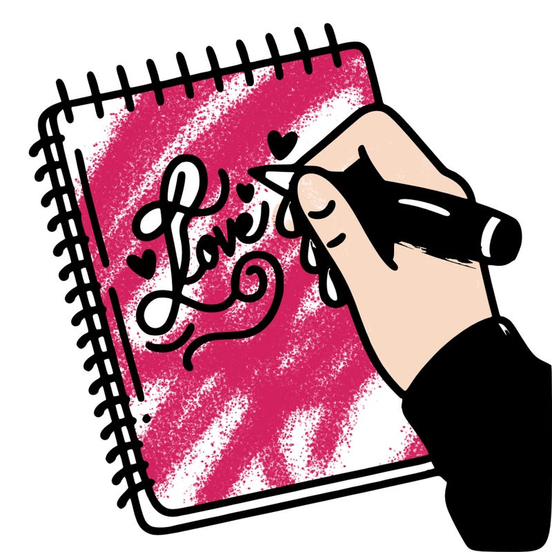 a hand writing “love” in calligraphy on a notebook
