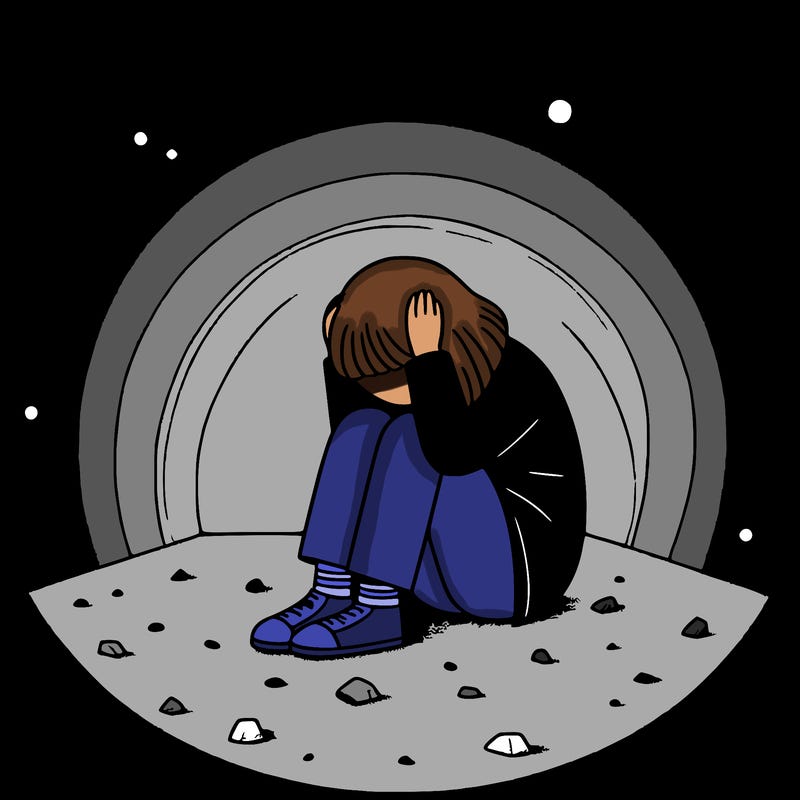 a girl huddled up against the wall on the floor with her hands on her head