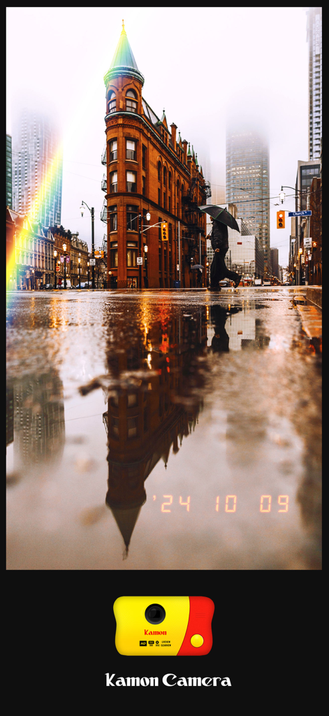 A city building reflected in a puddle with a vintage film effect and date stamp from the Kamon app