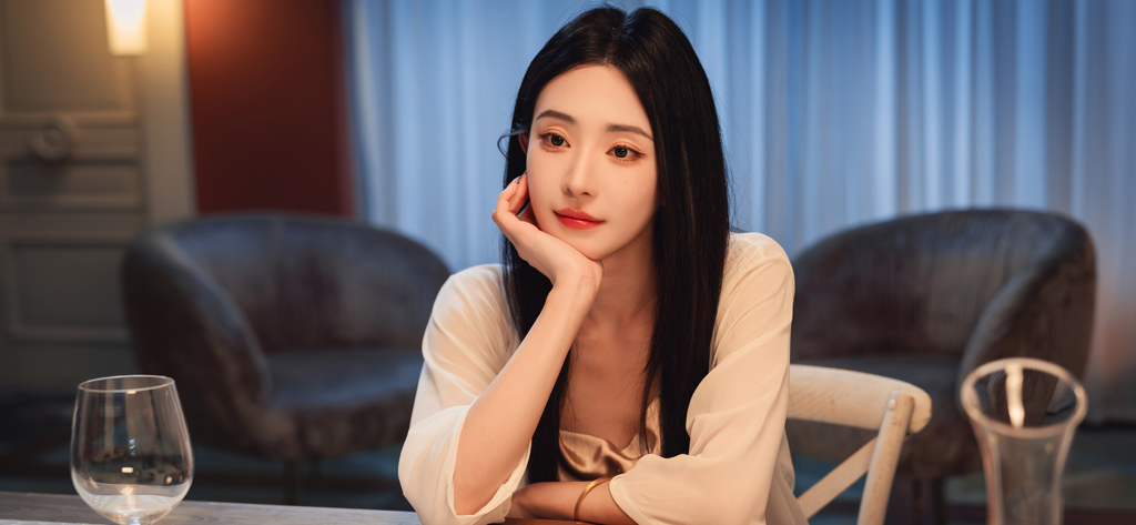 Una joven hermosa con el pelo largo y negro apoyando la barbilla en la mano en una escena cinematográfica.