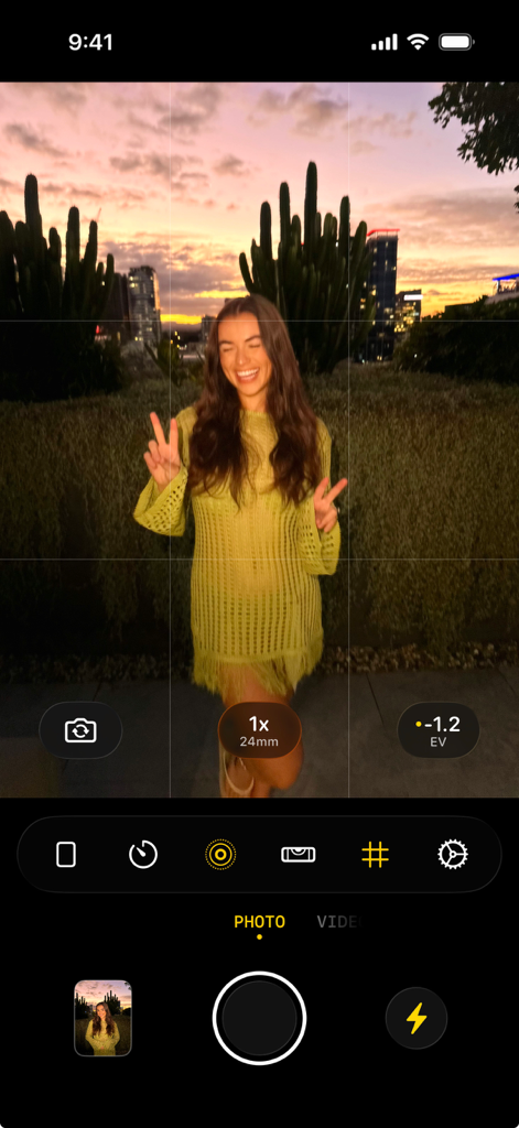Camera interface of flag7x app capturing a g7x style aesthetic photo of a smiling woman at sunset with exposure and lens settings