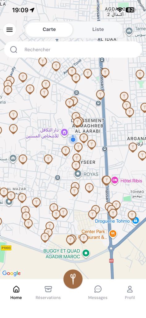 Mobile app screen showing a map with multiple icons of scissors representing available hairdressers for booking.