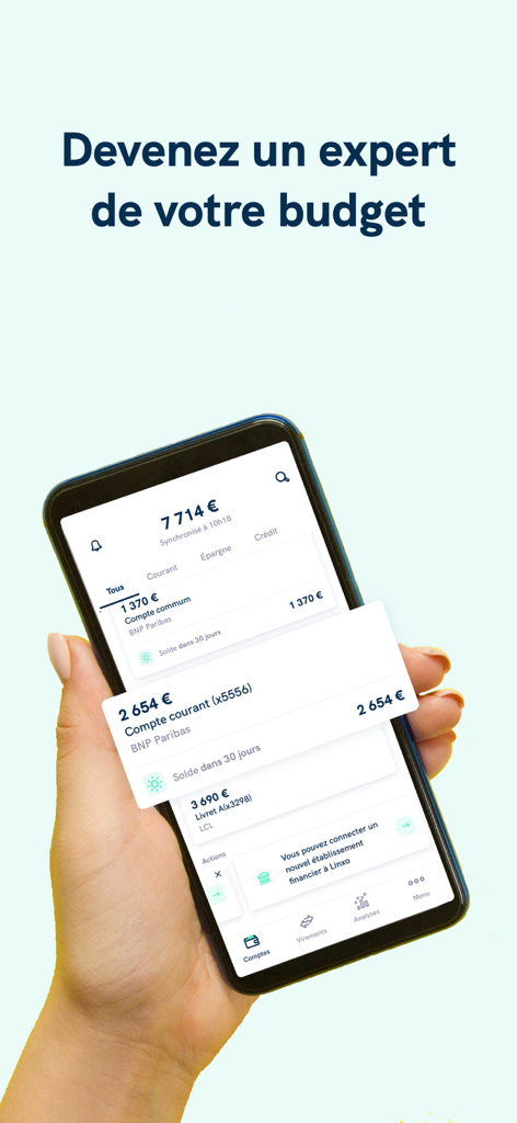 Linxo - L'app n°1 de budget - Hand holding a smartphone displaying the Linxo app interface with multiple bank account balances and budget analysis