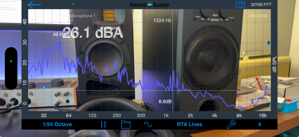SoundScope VR - SoundScope VR app displaying an RTA line graph and decibel level over a live camera view of studio equipment