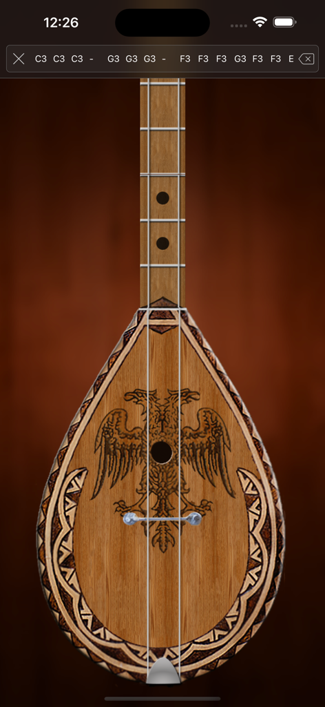 Tingalin (Çifteli and Lahuta) - Interface of the Tingalin app showing a virtual Albanian Cifteli instrument with a traditional double headed eagle carving