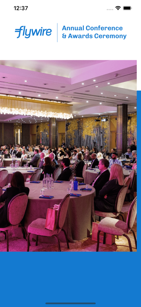 Flywire Annual Conference and Awards Ceremony event screen with people at a gala dinner