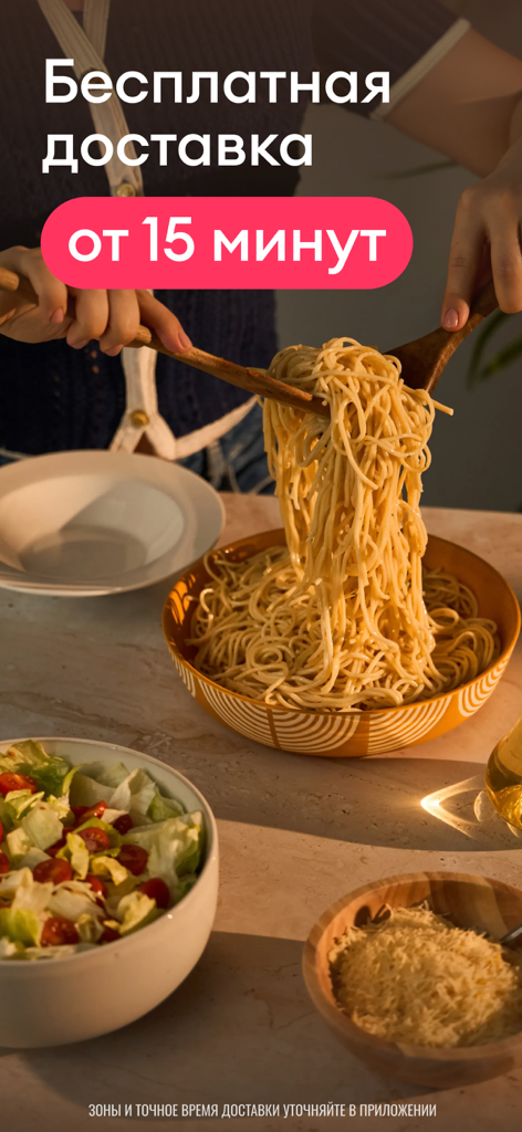 Una persona serve una ciotola di pasta con un'insalata a lato e formaggio pubblicizzando la consegna Samokat in 15 minuti