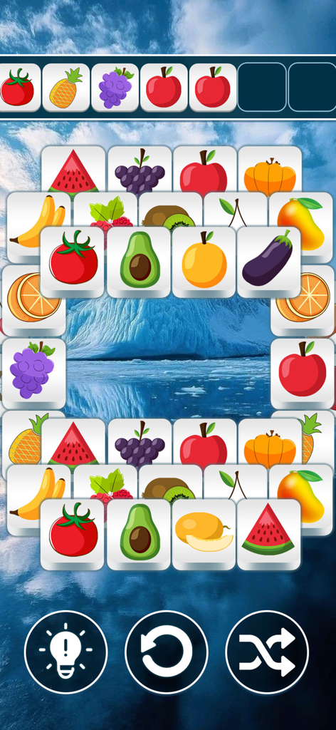 Sweet Fusion: Tile Match - リラックスできる氷山の背景の上にカラフルなフルーツタイルが特徴のSweet Fusion Tile Matchのゲームプレイ画面