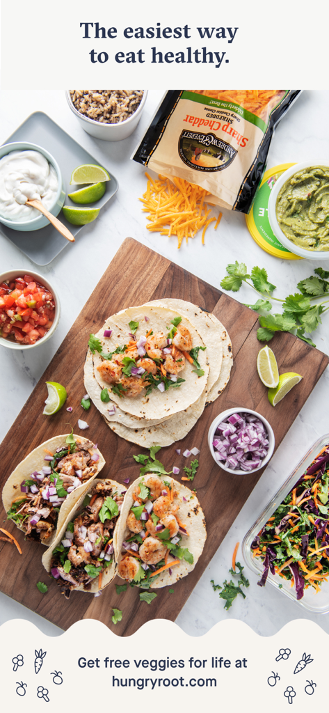 Köstliche Garnelen-Tacos auf einem Holzbrett mit frischen Toppings wie geriebenem Käse, Salsa und Guacamole
