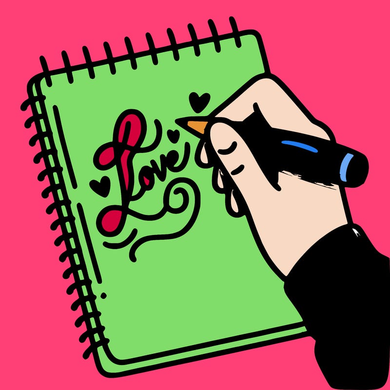 a hand writing “love” in calligraphy on a notebook