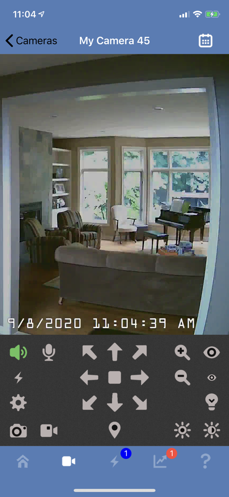 Blue Iris mobile app interface showing a live security camera feed of a living room with PTZ and audio controls