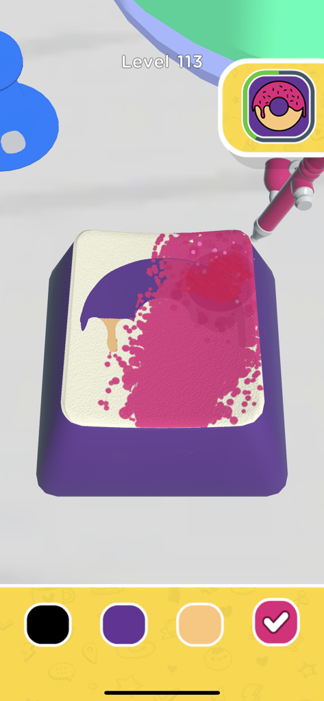 A keycap being decorated with pink spray paint and a stencil in the Keyboard Art mobile game