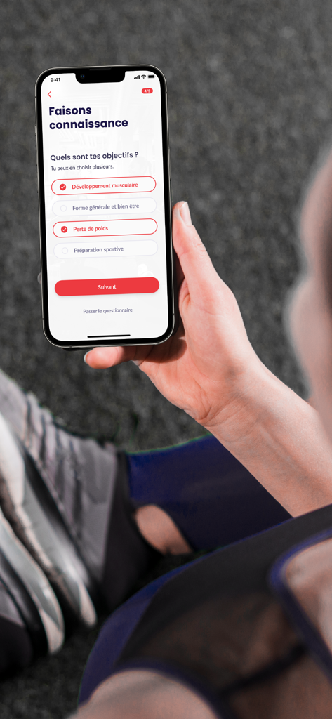 Neoness - Una persona sosteniendo un smartphone que muestra la pantalla de la aplicación Neoness donde los usuarios pueden seleccionar objetivos de fitness como desarrollo muscular y pérdida de peso.