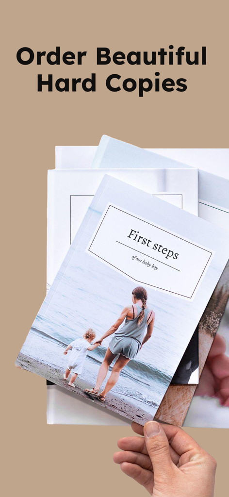 Baby Diaries - Book Journal - A hand holding a stack of high-quality printed baby photo books from the Baby Diaries app.