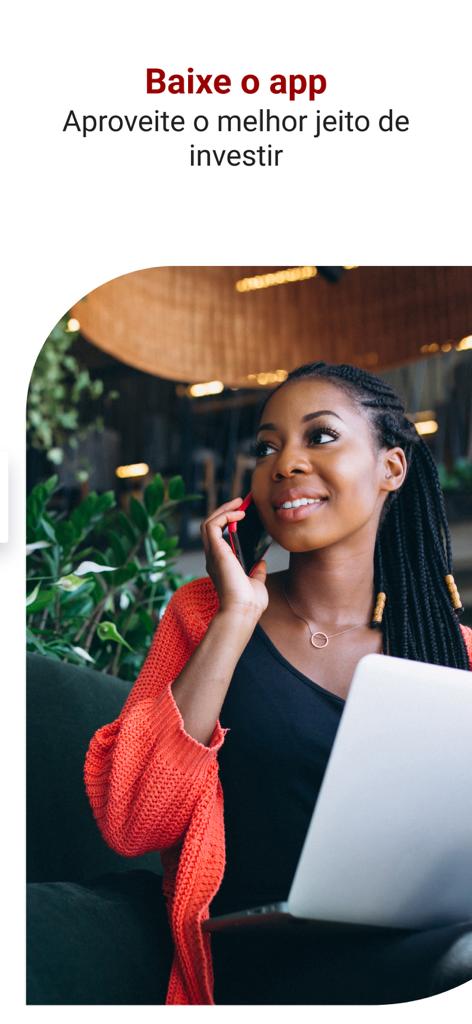 Santander Corretora: taxa 0 - A smiling woman using her phone and laptop to invest with the Santander Corretora app