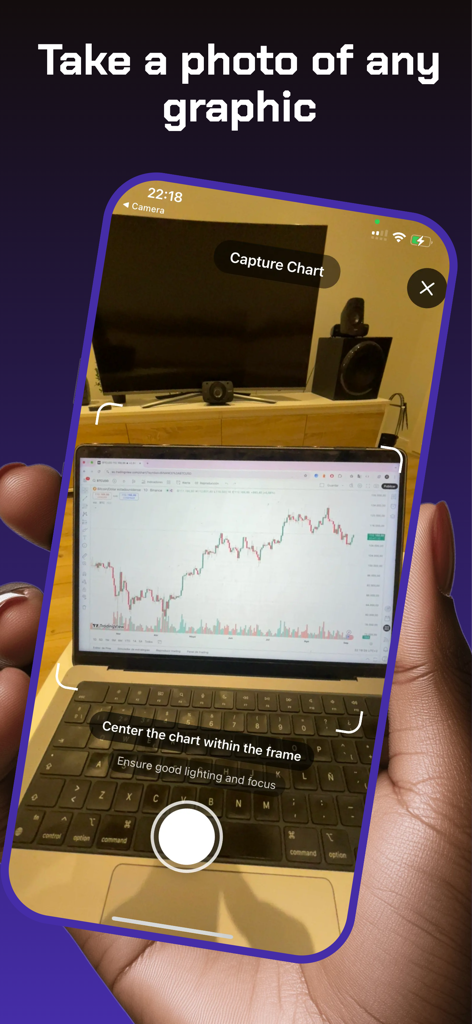 ラップトップ画面上の財務チャートをスキャンするためにTrading AIアプリのカメラを使用している人物。