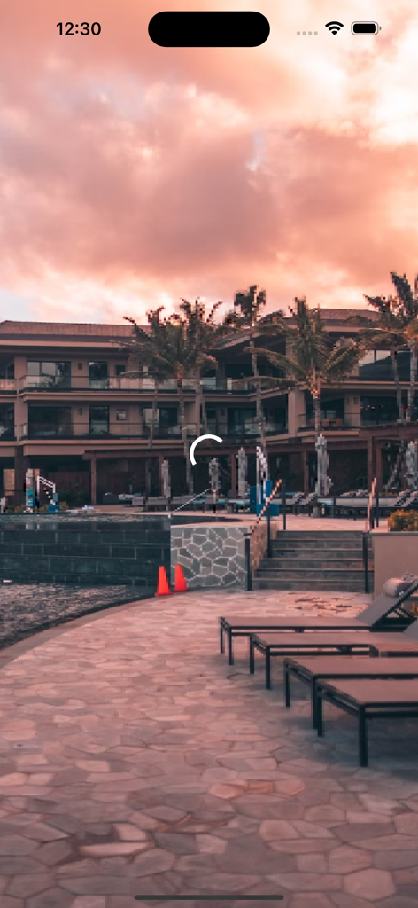 A luxury resort poolside with lounge chairs and palm trees under a sunset sky